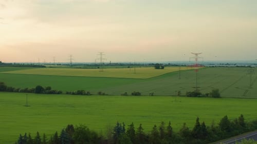 Stromübertragungsleitungen im Feld bei Sonnenuntergang Luftbild