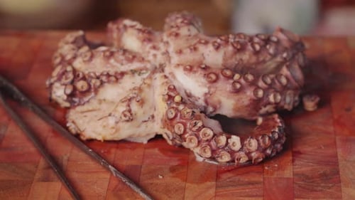 Close up dolly in and out shot of a cooked eight legged molluscs octopus with hot steam visibly appe