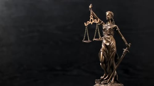 Bronze statue of themis or lady of justice on black background. Legal law.