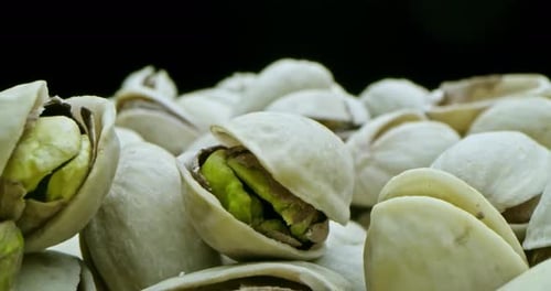 Close Up of Pistachios with Shells on Black