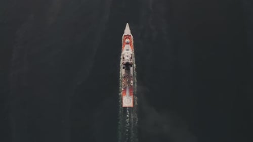 Drone View of a Modern Corvetteclass Ship Going Out to Sea Under the Bridge