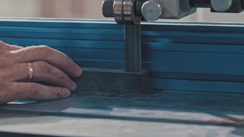 Carpentry Works Worker Slowly Cutting Along the Wooden Detail with an Automatic Saw Making It Two