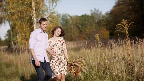 Young Couple Walking on a Meadow