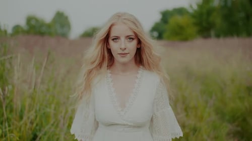 Woman in White Dress Walks Through Field