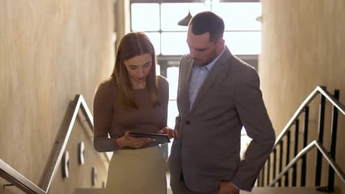 Colleagues Discussing Work on Tablet Indoors