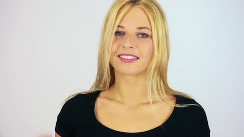 A Young Attractive Woman Waves at the Camera with a Smile - Face Closeup - White Screen Studio