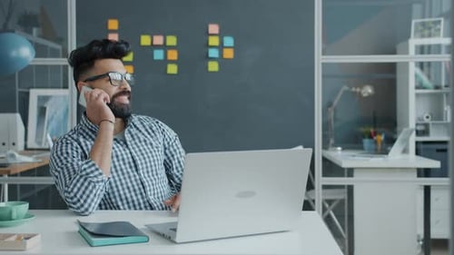 Young Adult Man Talking on Cell Phone in Office