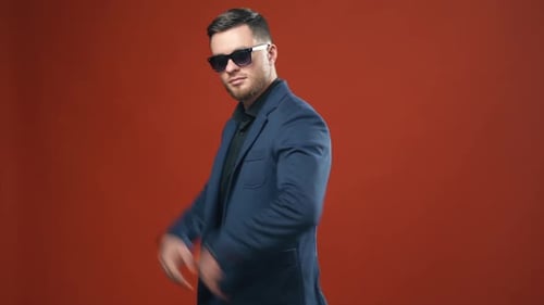 Stylish Man Poses in Sunglasses and Suit