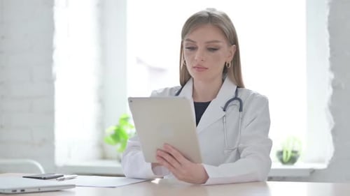 Lady Doctor Using Tablet While Sitting in Clinic