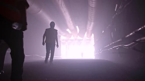 Silhouette vieler Bauarbeiter, die aus einem großen Tunnel herauskommen