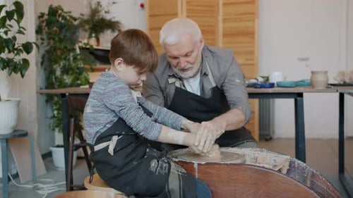 Grandfather and Child Working with Pottery Clay