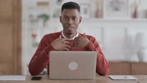 African Man with Laptop Talking on Video Call in Office