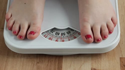 Bare Feet Stepping onto Bathroom Scale