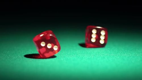 Dados rojos del casino rodando sobre la mesa verde en cámara lenta