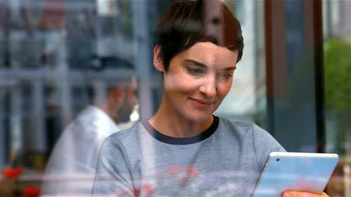 Young Woman Using Tablet in Urban Cafe