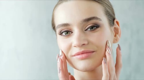Glamorous Woman Applying Skincare Products to Face