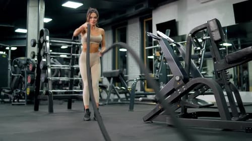 Fitte Brünette Frau beim Battle Rope
