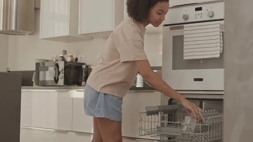 Biracial Girl Loading Dishwasher