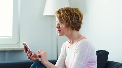 Woman sitting on a gray sofa and chatting video