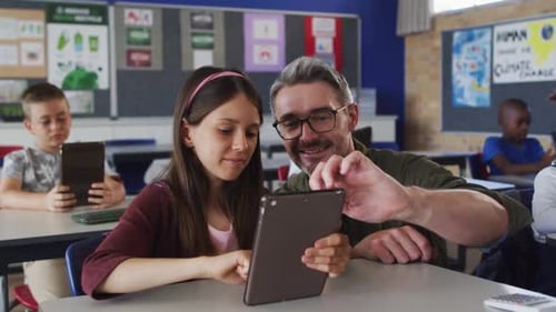 Teacher Helping Student with Tablet in Classroom