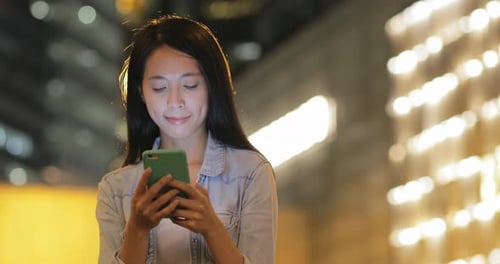 Woman using mobile phone at night