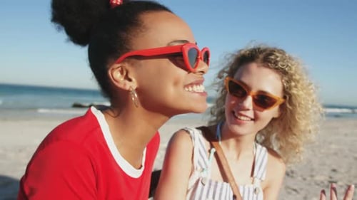 Two young adult female friends having fun at the beach 4k