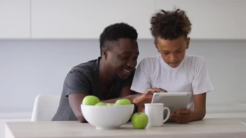 Boy and Man Using Tablet Device at Home