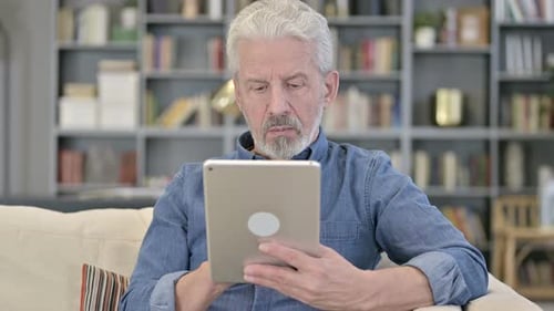 Senior Man Using Tablet Device at Home