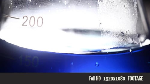 Blue Liquid Agitating in Scientific Beaker Close Up