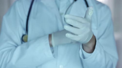 Healthcare Provider Puts on Medical Gloves