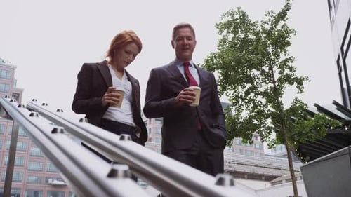 Business People Walking Down Stairs With Coffee