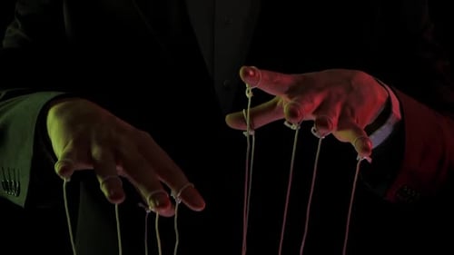 Geschäftsmann Leader in einem Anzug manipuliert die Marionettenschnüre, die an seine Finger gebunden sind