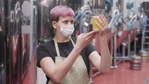 Female Brewery Worker With Freshly Made Beer