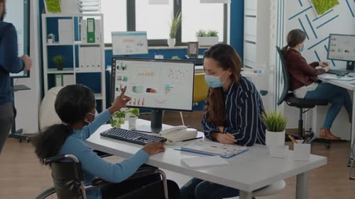 Entrepreneur africain immobilisé travaillant avec un collègue dans un nouveau bureau normal