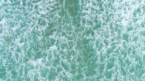 Top Down Aerial View of Giant Ocean Waves Crashing and Foaming.