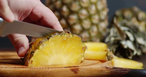 Chef Slicing Fresh Pineapple on Cutting Board