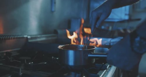 Chef Cooking Food Over Flames on Stovetop