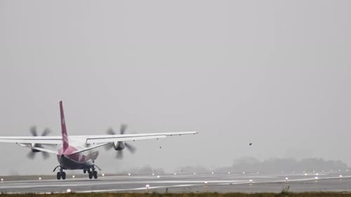 The Plane Travels on the Runway in Rainy Weather