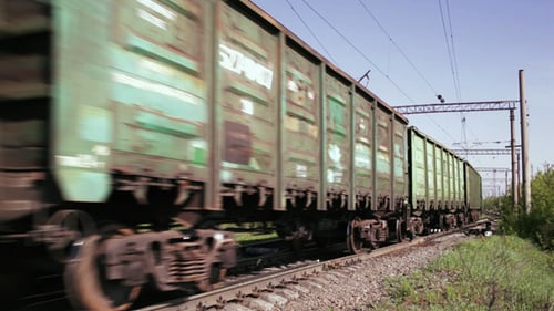 Green Train Moving Along Railroad Tracks