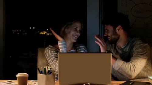 Young Adults Working Together on Laptop Late Night