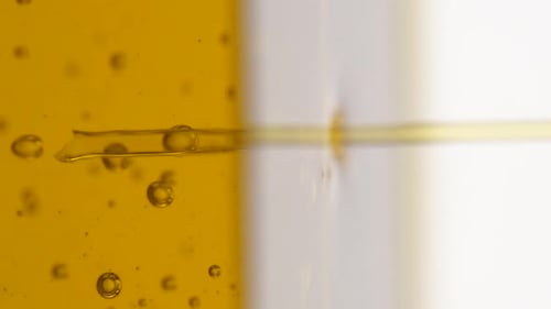 Vertical video: pouring olive oil into a glass