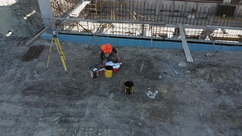 Unerkennbarer Baustellenleiter betrachtet die Grundrisse im Stehen