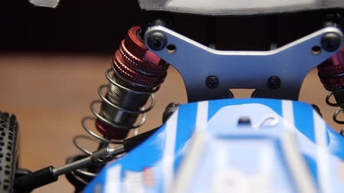 Primer plano de los elementos de suspensión del modelo de control de radio, coche de buggy sobre tapete