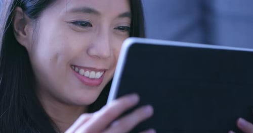 Woman Smiles Using Tablet Computer