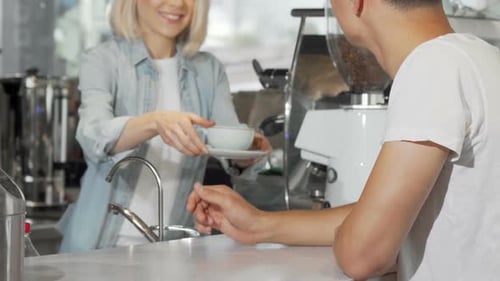 Barista Serving Customer Coffee at Counter
