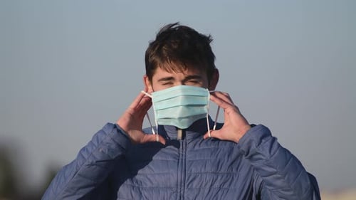 Close Up View of Man with Protective Mask Looking To Camera. Portrait of Young Guy in Medical Mask