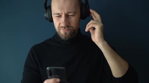 Man Listening to Music on Phone with Headphones