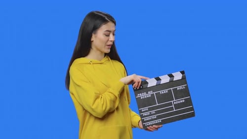 Young Woman with Clapperboard on Blue Background