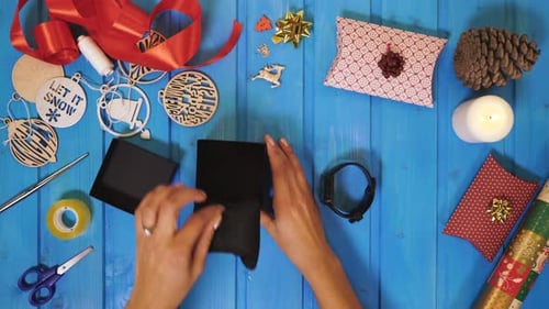 Hands Preparing Christmas Gift with Smart Watch
