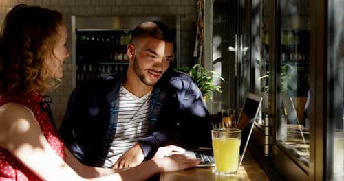 Young Adults Working Together at Cafe on Laptop